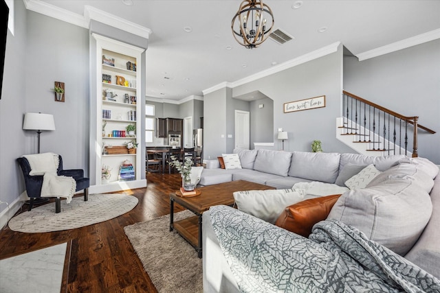 living area with stairs, a notable chandelier, wood finished floors, visible vents, and ornamental molding