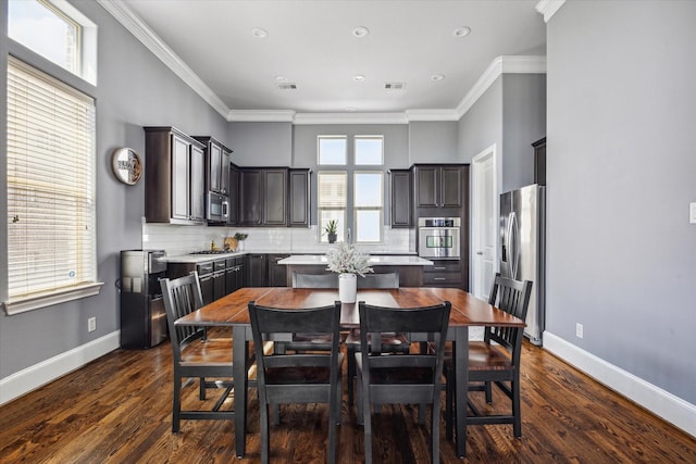 dining room with visible vents, ornamental molding, baseboards, and dark wood finished floors