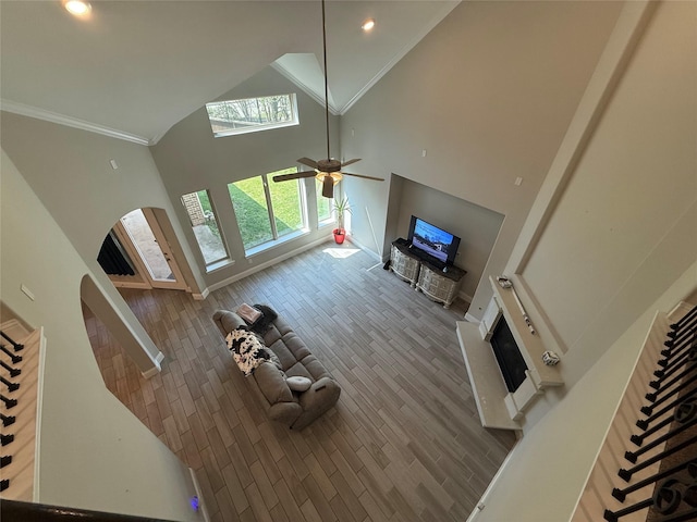 29431 Amber Meadows Ct, Katy, TX 77494 - unfurnished living room with crown molding, high vaulted ceiling, a ceiling fan, a fireplace, and wood finished floors