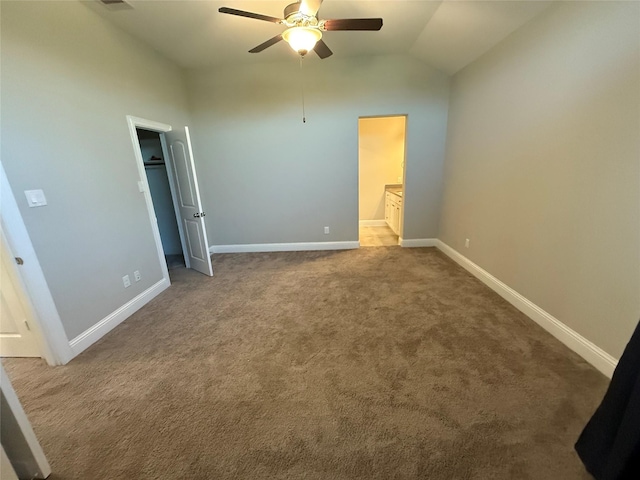 29431 Amber Meadows Ct, Katy, TX 77494 - unfurnished bedroom with vaulted ceiling, a walk in closet, baseboards, visible vents, and carpet
