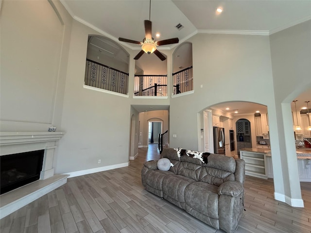 29431 Amber Meadows Ct, Katy, TX 77494 - living area featuring arched walkways, crown molding, light wood-style flooring, and a ceiling fan