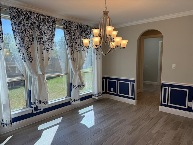 29431 Amber Meadows Ct, Katy, TX 77494 - unfurnished dining area with wood finished floors, ornamental molding, a chandelier, arched walkways, and wainscoting