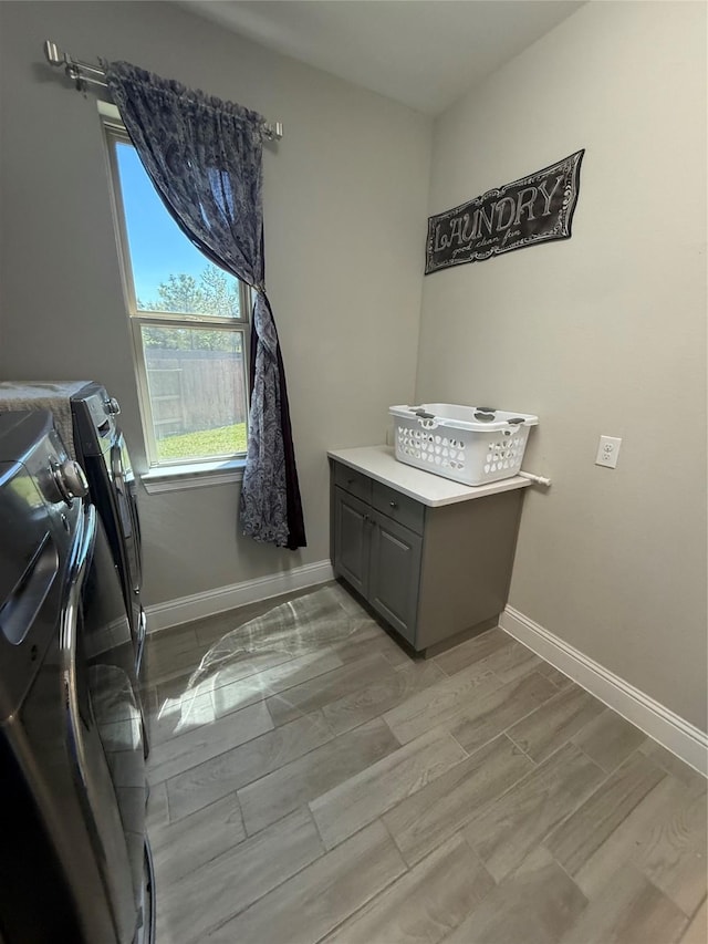 29431 Amber Meadows Ct, Katy, TX 77494 - laundry room with baseboards, washing machine and dryer, wood tiled floor, and cabinet space