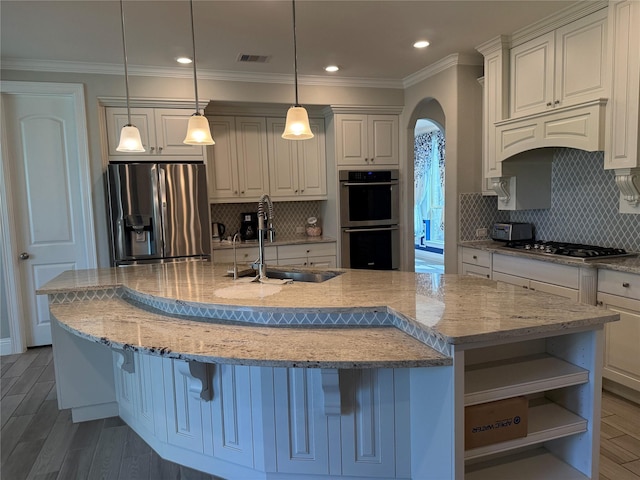 29431 Amber Meadows Ct, Katy, TX 77494 - kitchen with arched walkways, a sink, wood finished floors, and appliances with stainless steel finishes