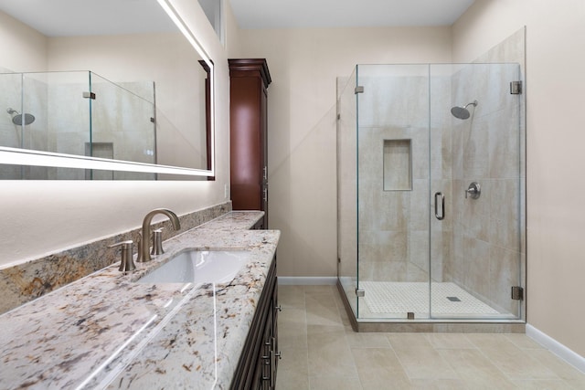 9171 Briar Frst, Houston, TX 77024 - bathroom featuring baseboards, vanity, tile patterned flooring, and a stall shower