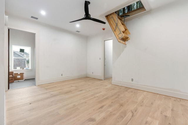 empty room with visible vents, ceiling fan, wood finished floors, and baseboards