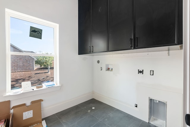 laundry area with baseboards, dark tile patterned floors, hookup for an electric dryer, cabinet space, and hookup for a washing machine