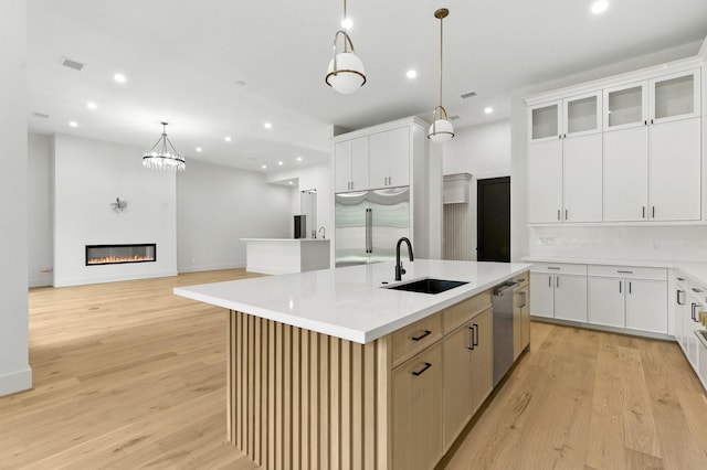 6536 Community Dr, West University Place, TX 77005 - kitchen with an island with sink, light wood-style floors, light countertops, pendant lighting, and recessed lighting