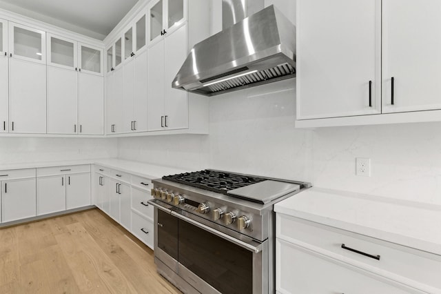6536 Community Dr, West University Place, TX 77005 - kitchen featuring wall chimney exhaust hood, double oven range, backsplash, light wood finished floors, and light countertops