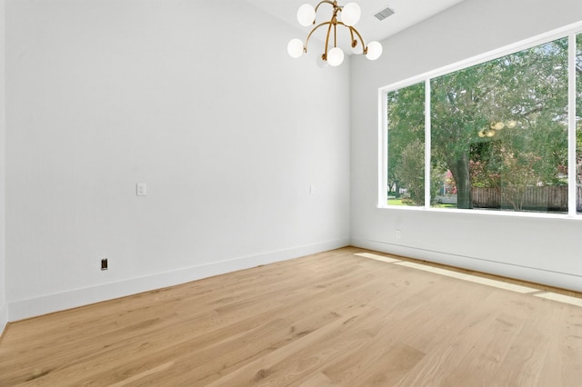 6536 Community Dr, West University Place, TX 77005 - unfurnished room with wood finished floors, plenty of natural light, and a chandelier