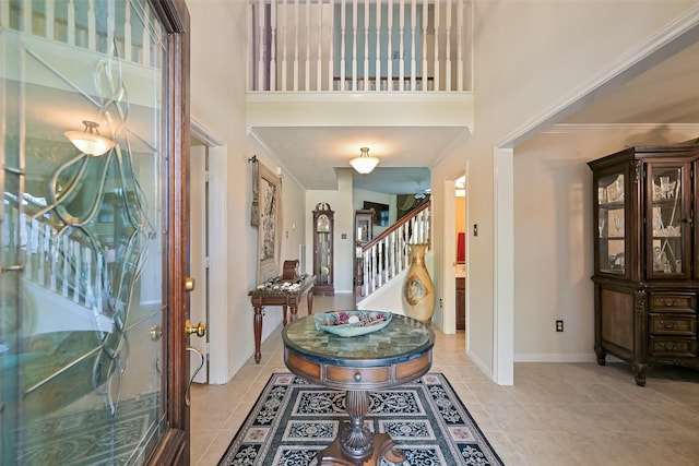 11204 Edwards Ave, Pearland, TX 77584 - entryway with stairway, light tile patterned floors, baseboards, a high ceiling, and ornamental molding