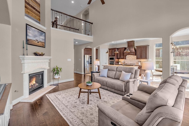2316 Iron Ridge Ln, Friendswood, TX 77546 - living area featuring dark wood-type flooring, arched walkways, baseboards, and a glass covered fireplace