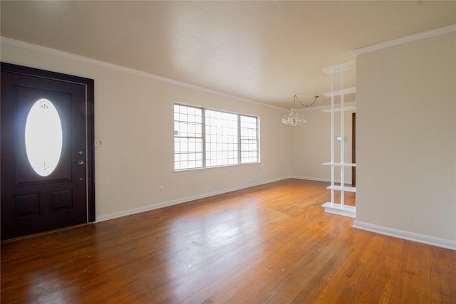 6038 Belcrest St, Houston, TX 77033 - foyer entrance with a chandelier, light wood-style flooring, crown molding, and baseboards