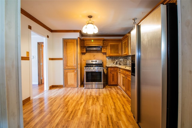 6038 Belcrest St, Houston, TX 77033 - kitchen with stainless steel appliances, exhaust hood, brown cabinets, light wood-type flooring, and backsplash