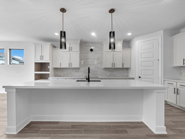 3193 Stingray Cove Dr, Katy, TX 77493 - kitchen featuring a spacious island, decorative backsplash, light wood-style flooring, white cabinetry, and decorative light fixtures