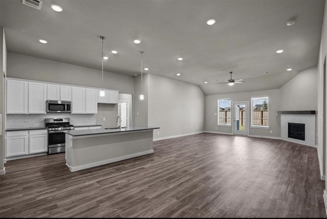 716 Ivory Creek Ct, Willis, TX 77378 - kitchen featuring dark countertops, a sink, stainless steel appliances, open floor plan, and visible vents