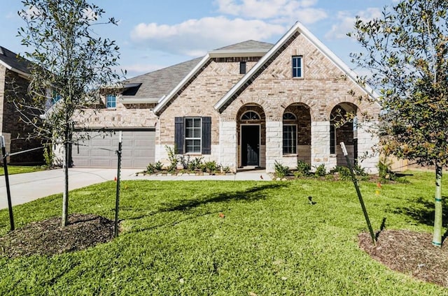 716 Ivory Creek Ct, Willis, TX 77378 - french country home with an attached garage, concrete driveway, a front yard, and brick siding