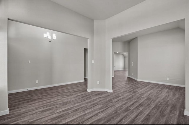 716 Ivory Creek Ct, Willis, TX 77378 - spare room with baseboards, lofted ceiling, dark wood-style floors, and a notable chandelier