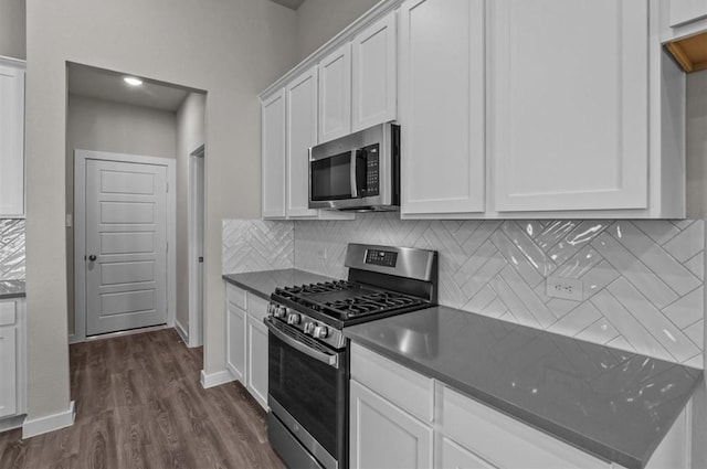 716 Ivory Creek Ct, Willis, TX 77378 - kitchen featuring dark countertops, tasteful backsplash, white cabinets, dark wood-style floors, and stainless steel appliances