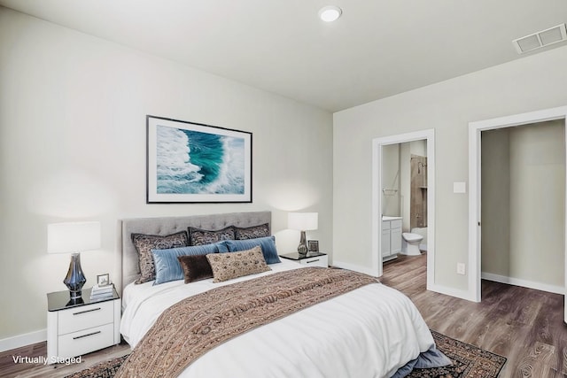 716 Ivory Creek Ct, Willis, TX 77378 - bedroom featuring baseboards, ensuite bathroom, wood finished floors, and visible vents