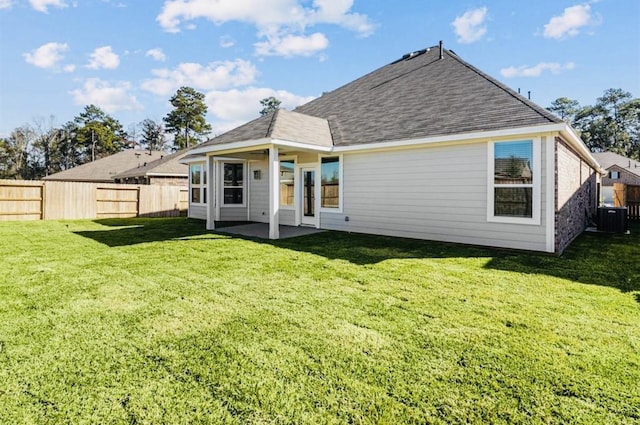 716 Ivory Creek Ct, Willis, TX 77378 - back of property featuring a lawn, a fenced backyard, and central AC