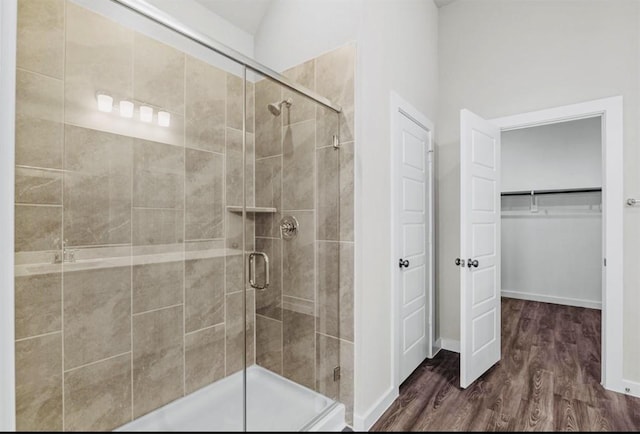 716 Ivory Creek Ct, Willis, TX 77378 - bathroom featuring baseboards, a walk in closet, wood finished floors, and a shower stall