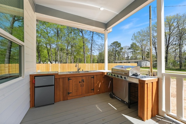 200 Canary St, Point Blank, TX 77364 - wooden deck with a sink, an outdoor kitchen, fence, and view of scattered trees
