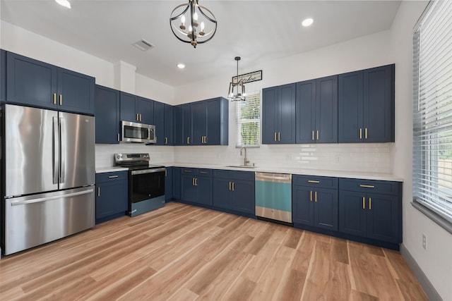 200 Canary St, Point Blank, TX 77364 - kitchen with appliances with stainless steel finishes, blue cabinetry, a sink, a chandelier, and recessed lighting