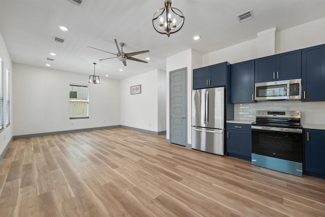 200 Canary St, Point Blank, TX 77364 - kitchen featuring stainless steel appliances, blue cabinetry, a chandelier, backsplash, and light countertops