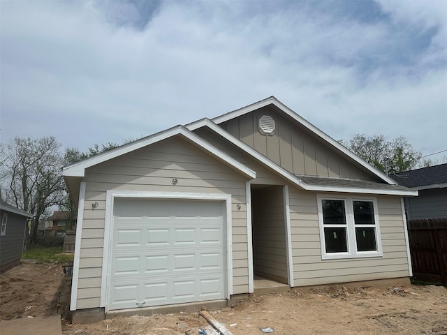 7981 Cinderella St, Houston, TX 77028 - ranch-style house with board and batten siding, fence, and an attached garage
