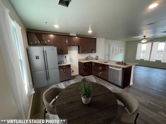 7981 Cinderella St, Houston, TX 77028 - kitchen with stainless steel dishwasher, freestanding refrigerator, dark brown cabinets, a peninsula, and wood finished floors