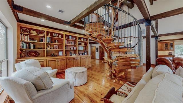 living room with stairs, beamed ceiling, visible vents, and wood finished floors