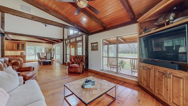 living area with lofted ceiling with beams, ceiling fan, wooden ceiling, and light wood finished floors