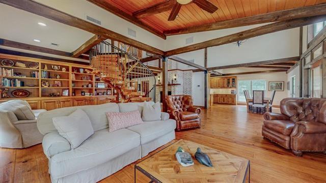 living room featuring stairway, wood-type flooring, wooden ceiling, beam ceiling, and a ceiling fan