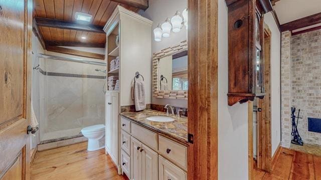 full bath featuring wooden ceiling, beam ceiling, vanity, a shower stall, and wood finished floors