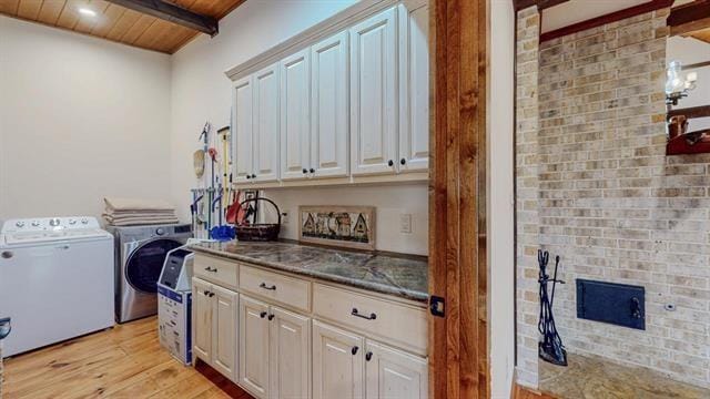 laundry room featuring light wood finished floors, wooden ceiling, cabinet space, and separate washer and dryer