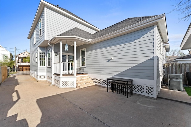rear view of property with fence, central AC, and a patio