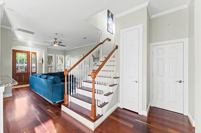 staircase with crown molding, baseboards, visible vents, a ceiling fan, and wood finished floors