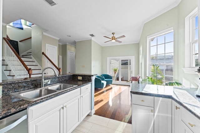 kitchen with white cabinetry, ornamental molding, stainless steel dishwasher, a sink, and visible vents
