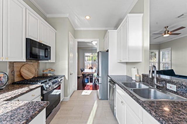 kitchen featuring white cabinets, visible vents, ornamental molding, appliances with stainless steel finishes, and a sink