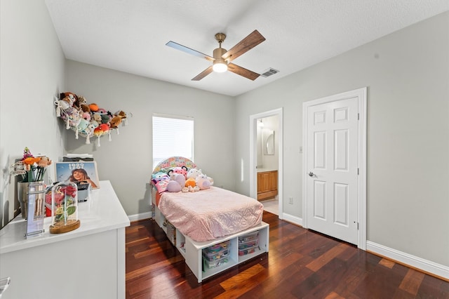 bedroom with baseboards, visible vents, and wood finished floors