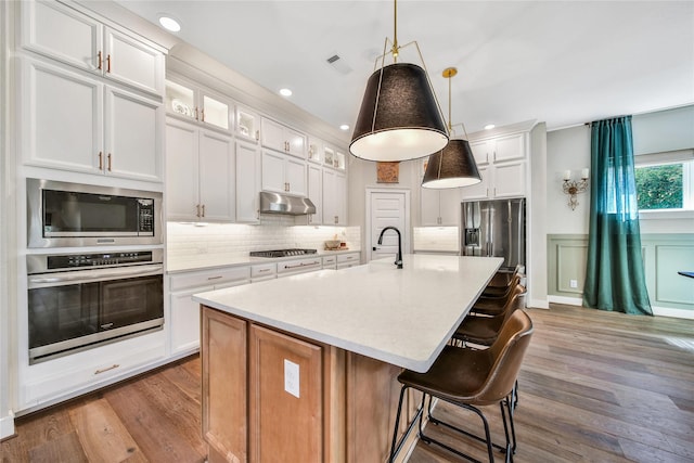 325 Bromley Square Dr, Montgomery, TX 77316 - kitchen featuring visible vents, light wood-type flooring, under cabinet range hood, and stainless steel appliances