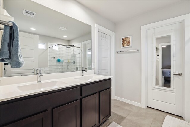 bathroom with double vanity, visible vents, a sink, and a stall shower