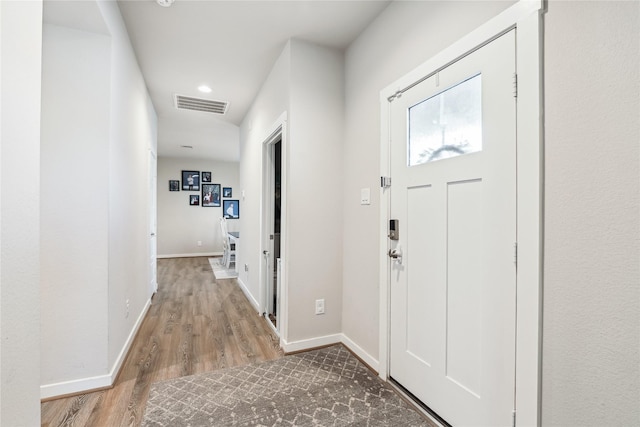 entrance foyer with baseboards, visible vents, and wood finished floors