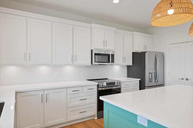 kitchen with recessed lighting, stainless steel appliances, light countertops, white cabinetry, and pendant lighting