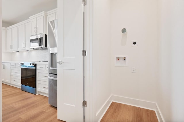 kitchen featuring white cabinets, appliances with stainless steel finishes, and light wood-style floors