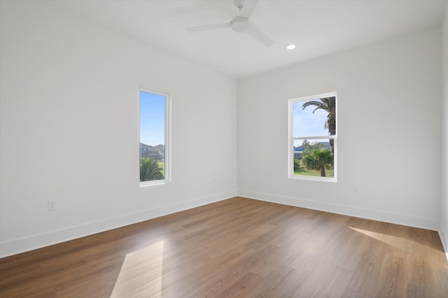 empty room featuring recessed lighting, a ceiling fan, wood finished floors, and baseboards