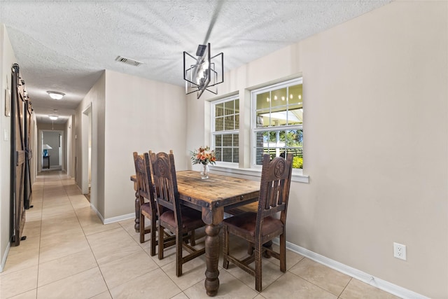 3358 County Road 172, Alvin, TX 77511 - dining room featuring baseboards, a textured ceiling, light tile patterned flooring, visible vents, and a notable chandelier