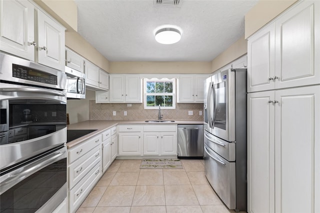 3358 County Road 172, Alvin, TX 77511 - kitchen with light countertops, backsplash, a sink, stainless steel appliances, and white cabinets