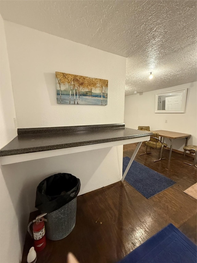 interior space with a textured ceiling and wood finished floors